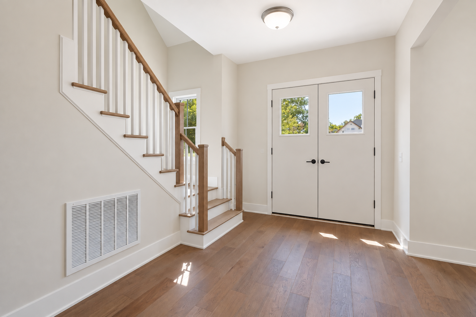 Before: white double doors with small windows, a plain wood and white stair rail and a standard ceiling light