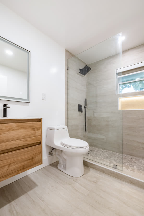 Bathroom with a floating wood vanity and a glass walk-in shower
