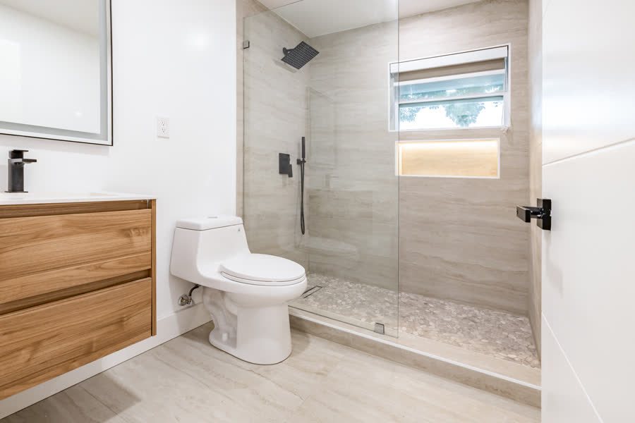 Bathroom with a floating wood vanity and a glass walk-in shower